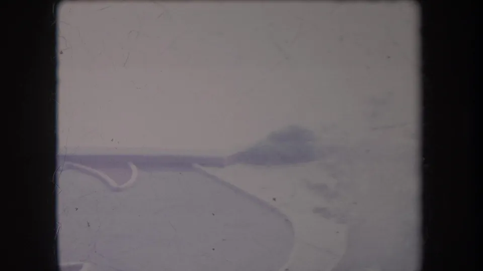 1969 Hawaii 8mm frame showing a pale curving road fork with soft greenery and distant haze.
