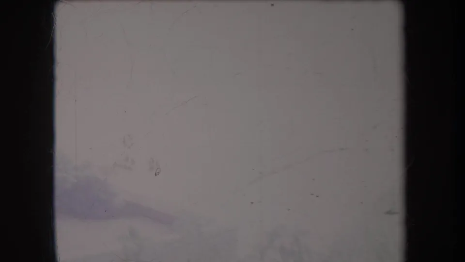 Soft 8mm frame from Hawaii in 1969 showing pale roadway and low roadside greenery during a handheld pan.
