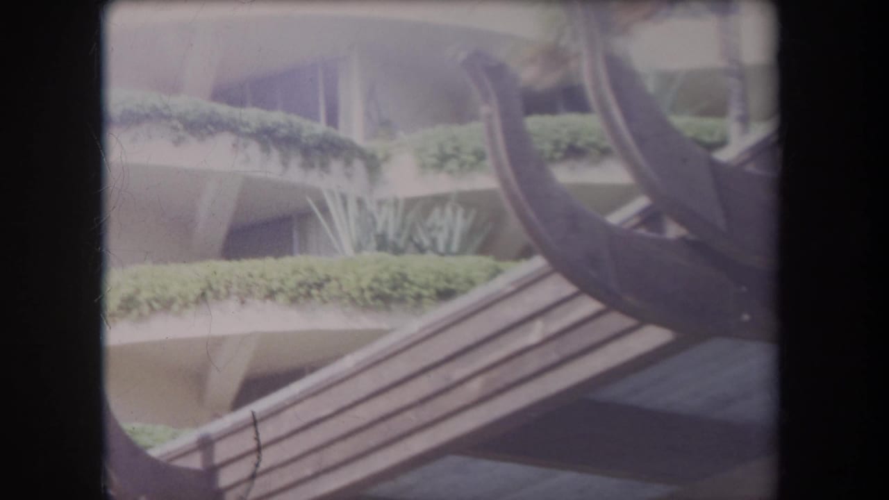 Concrete ledges with greenery above diagonal wood slats and curved dark beams.