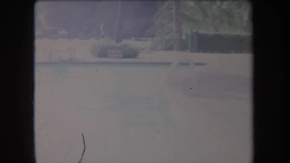 1969 Hawaii 8mm frame showing a hazy river or lagoon with faint palm and shoreline shapes in soft exposure.