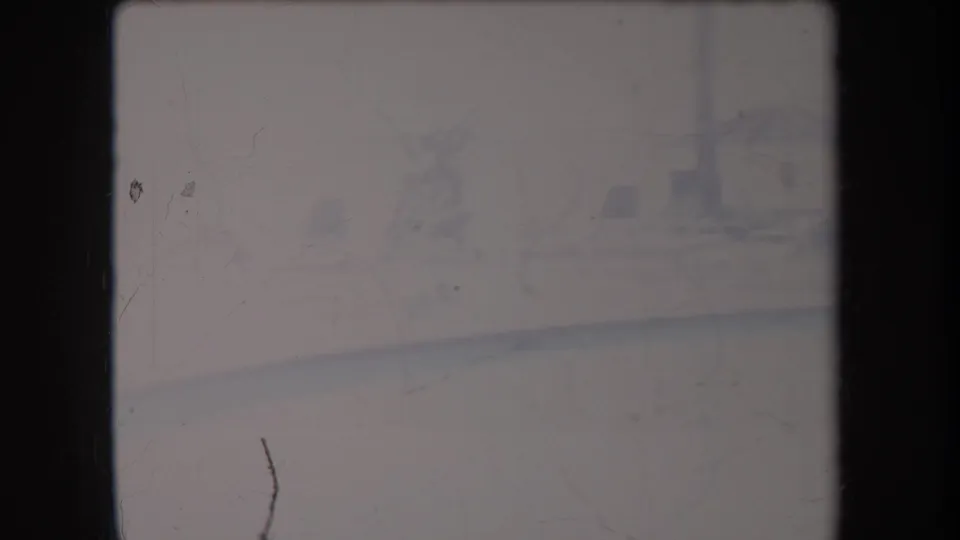 Overexposed 1969 Hawaii 8mm frame with misty water and faint palm-like vegetation along a distant shore.