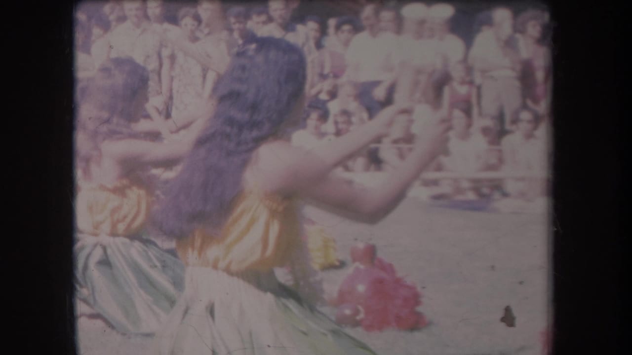 A dancer with long dark hair raises her arm while another dancer stands beside her.