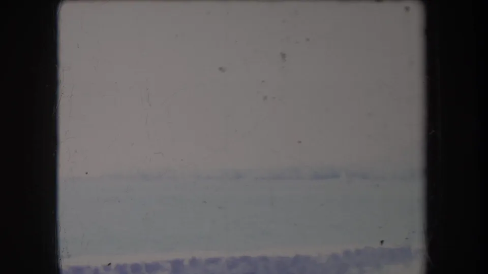 Hazy 1969 Hawaii 8mm frame showing a pale ocean horizon and sky with heavy overexposure and film marks.