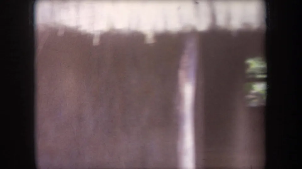 1969 Hawaii home-movie frame showing the hut interior or entrance area after the woman has moved out of the center of view.