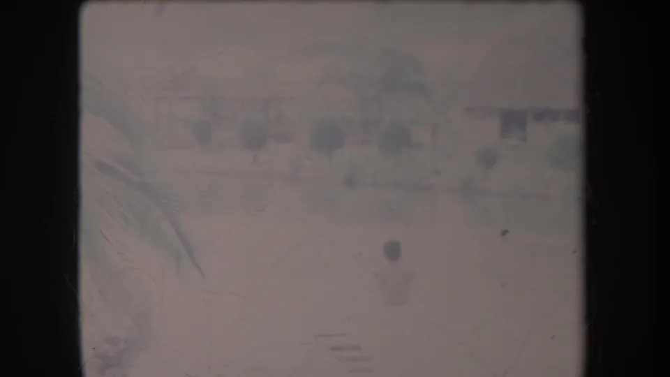 Soft 8mm frame from the Hawaii pool scene, with a person near the water and tropical landscaping visible through faded color.