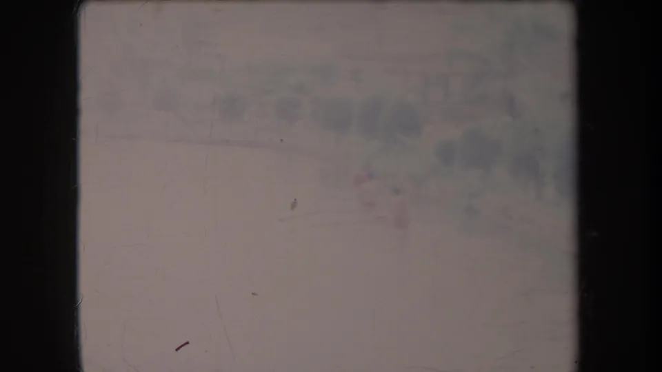 1969 Hawaii 8mm still showing a small distant boat on a calm lake, with a hazy tree line and faint structures beyond.