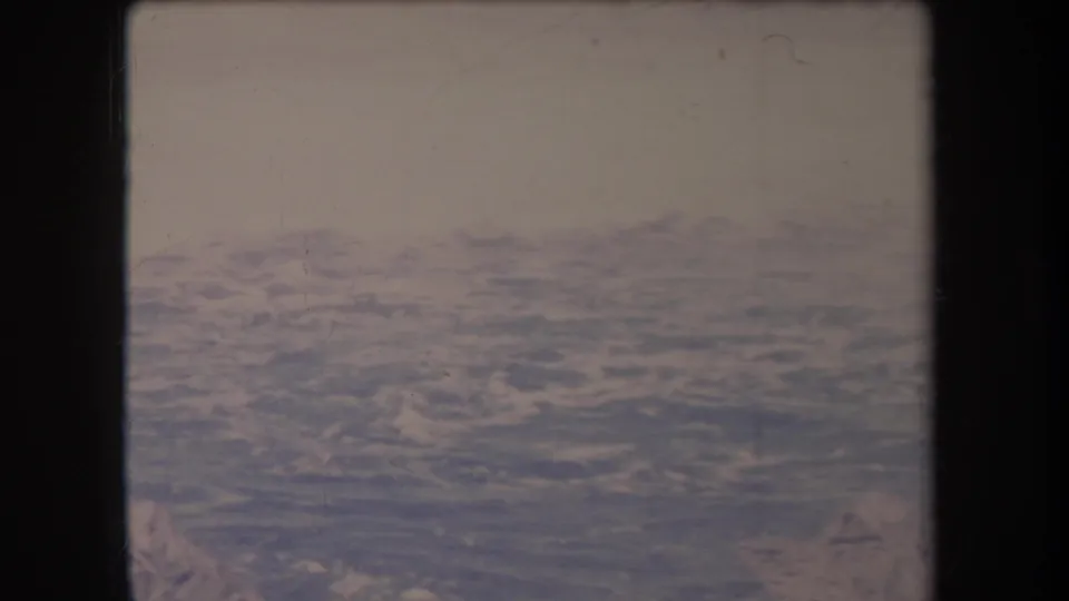 1969 Hawaii 8mm frame looking over blue Pacific water from above, with soft focus, grain, and dark film borders.
