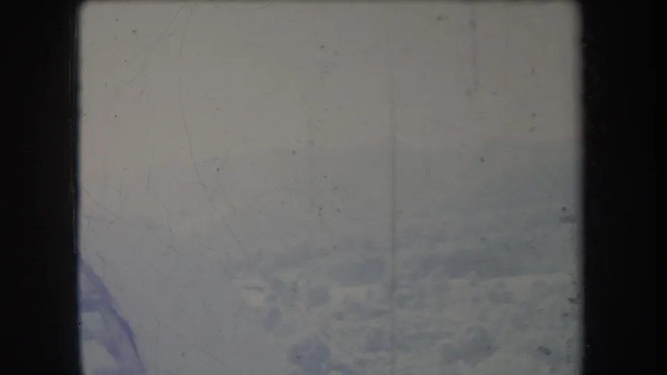 Faded 1969 Hawaii 8mm frame with a hazy mountain or hillside landscape, soft exposure, and visible dust and scratches.