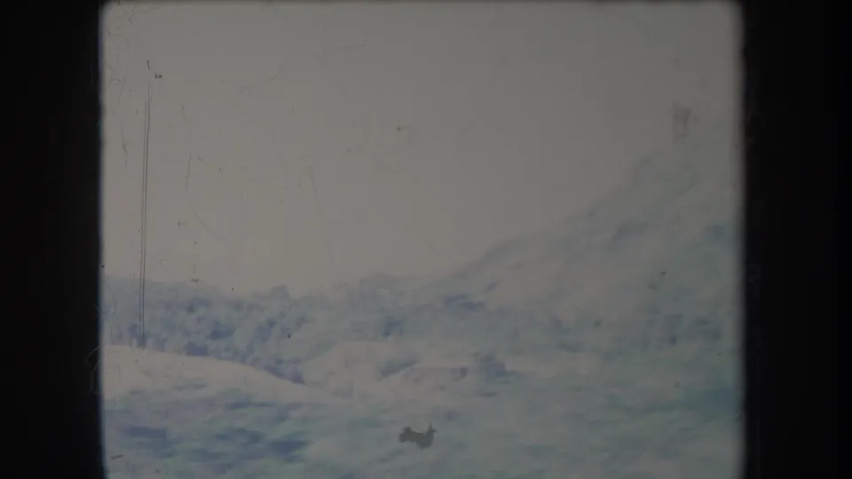 1969 Hawaii 8mm view of low pasture hills and a pale distant mountain slope in overcast conditions.