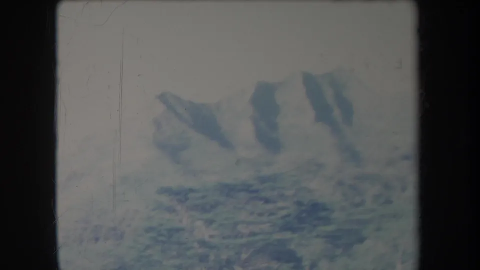 A faded 1969 Hawaii landscape frame with hazy ridgelines, green valley texture, and visible 8mm wear.