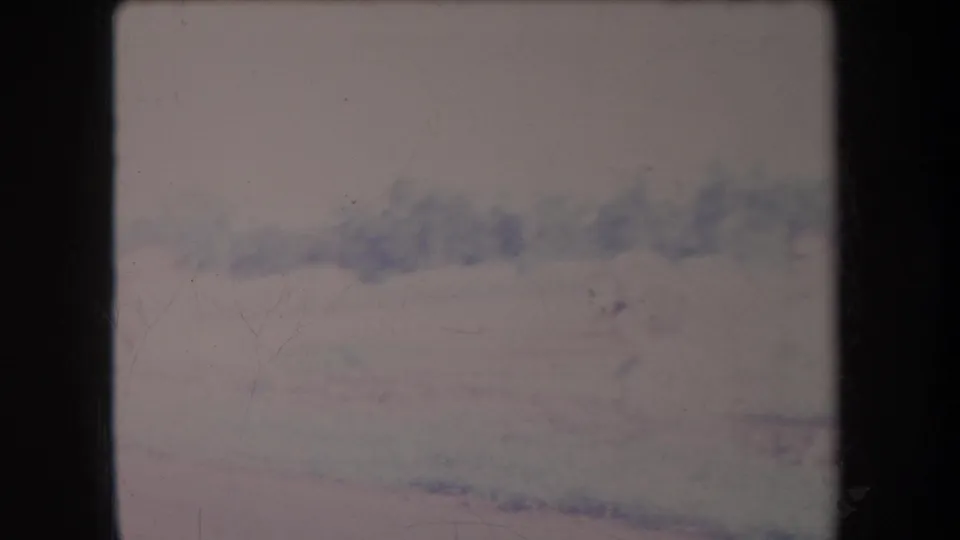 1969 Hawaii 8mm frame showing a hazy mountain landscape under a pale cloudy sky, with faded color and visible film wear.