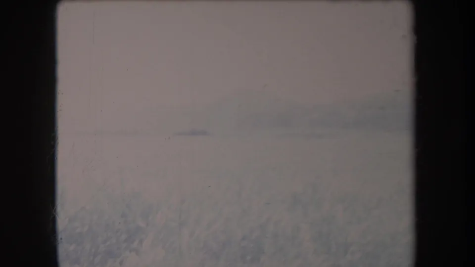 1969 Hawaii 8mm frame showing a soft, misty grassy valley with low hills under an overcast sky.