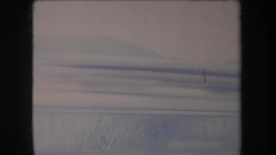 1969 Hawaii 8mm frame showing snow, low distant ridges, and motion-softened horizontal bands across the scene.