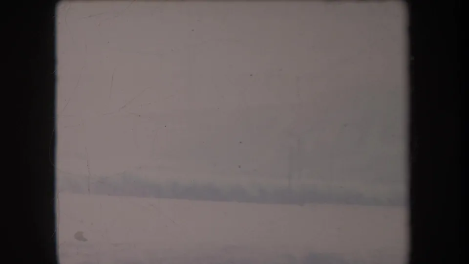 Soft 1969 Hawaii home-movie frame showing a hazy roadside landscape under an overcast sky.