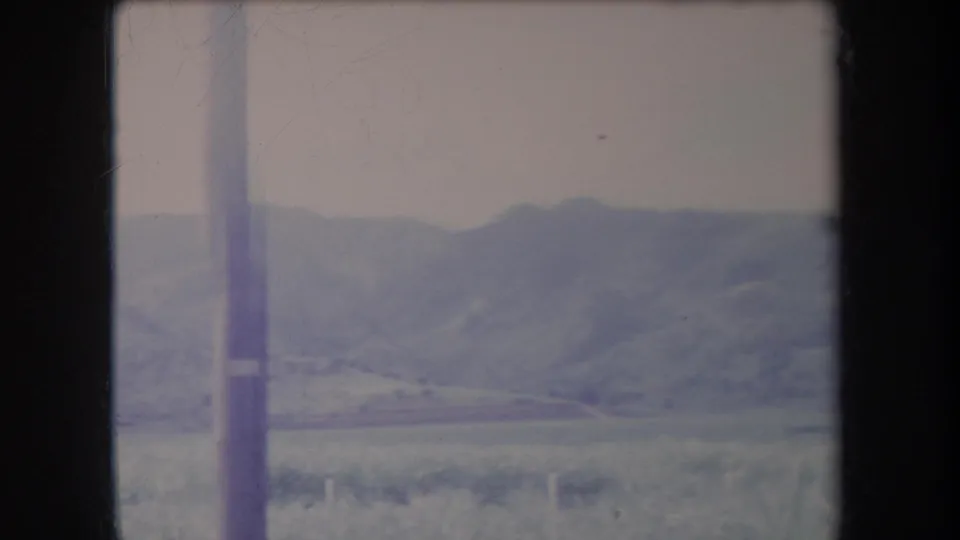 1969 Hawaii landscape frame with a vertical utility pole in front of distant hills and open grassland.