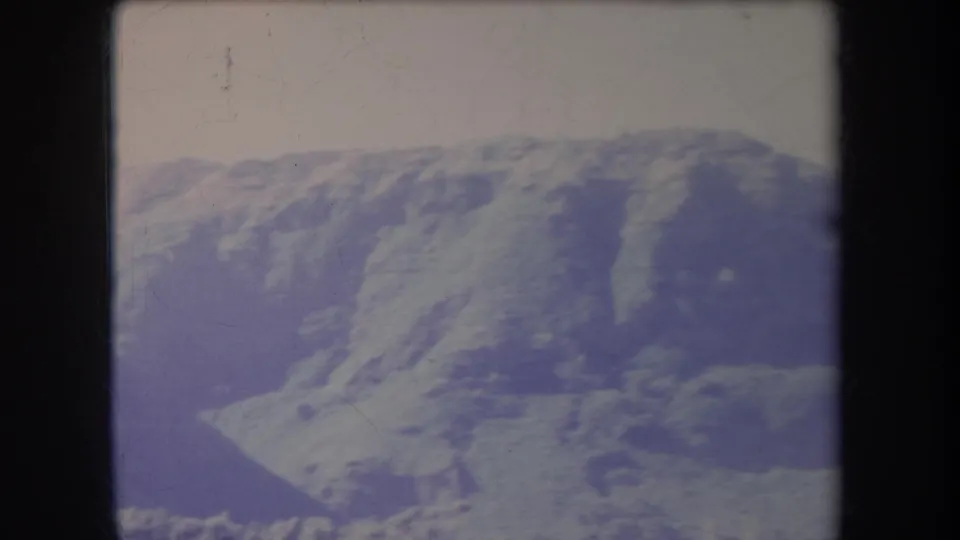1969 Hawaii home-movie frame showing a broad, treeless ridge with soft shadows and visible 8mm texture.