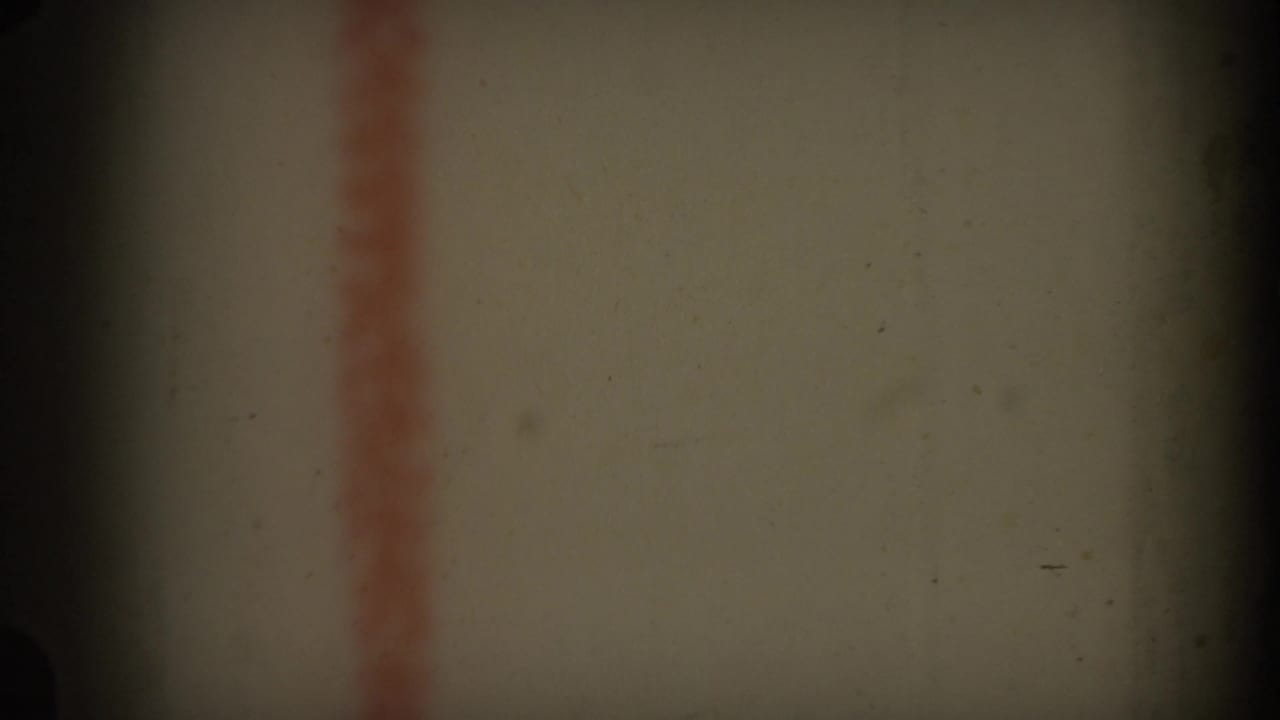 1969 Hawaii 8mm frame showing a close-up of an off-white surface with a soft red vertical stripe and shadowed film edges.