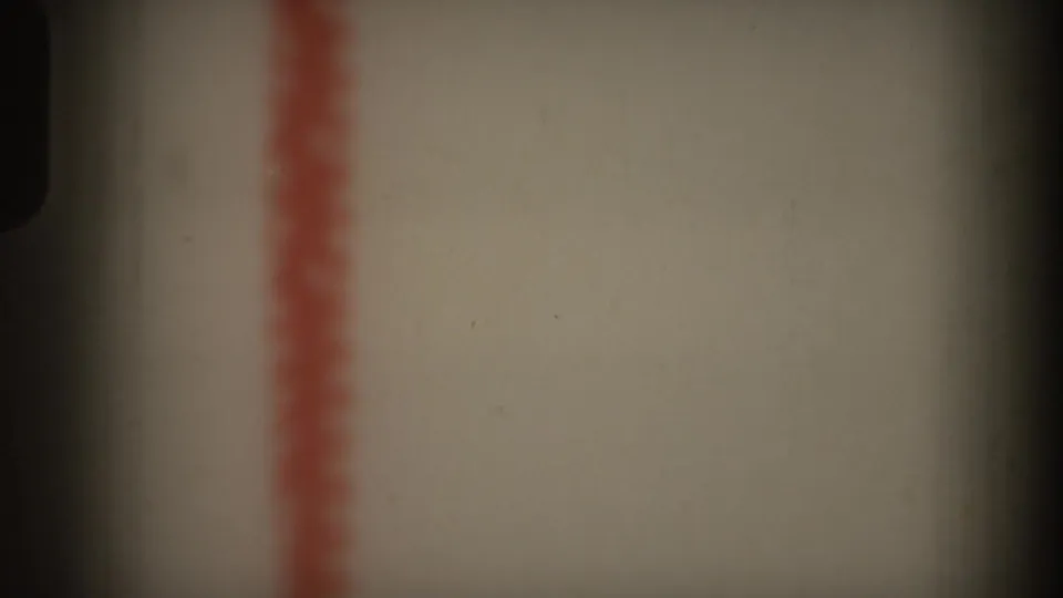 1969 Hawaii 8mm frame showing a cropped red vertical mark on a pale surface, with shadowing and visible film texture.