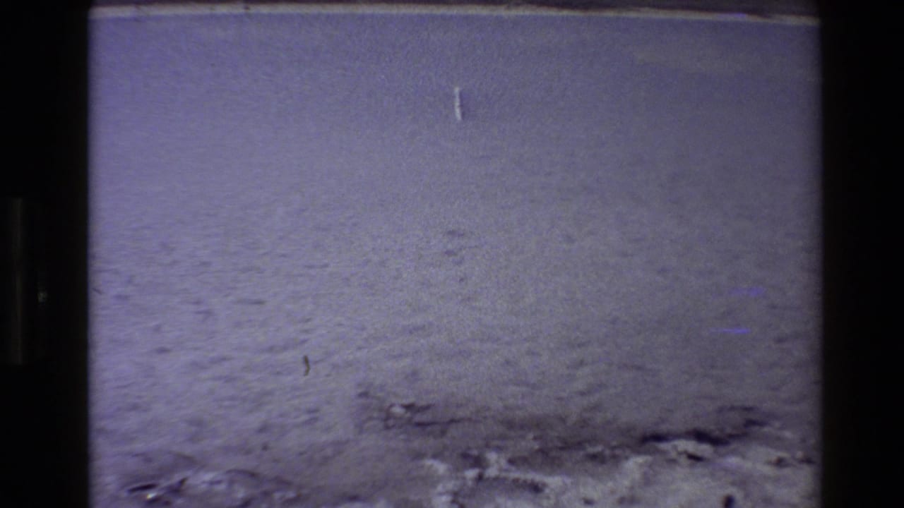 Snowy or frosty flat ground with faint marks and black 8mm frame borders.