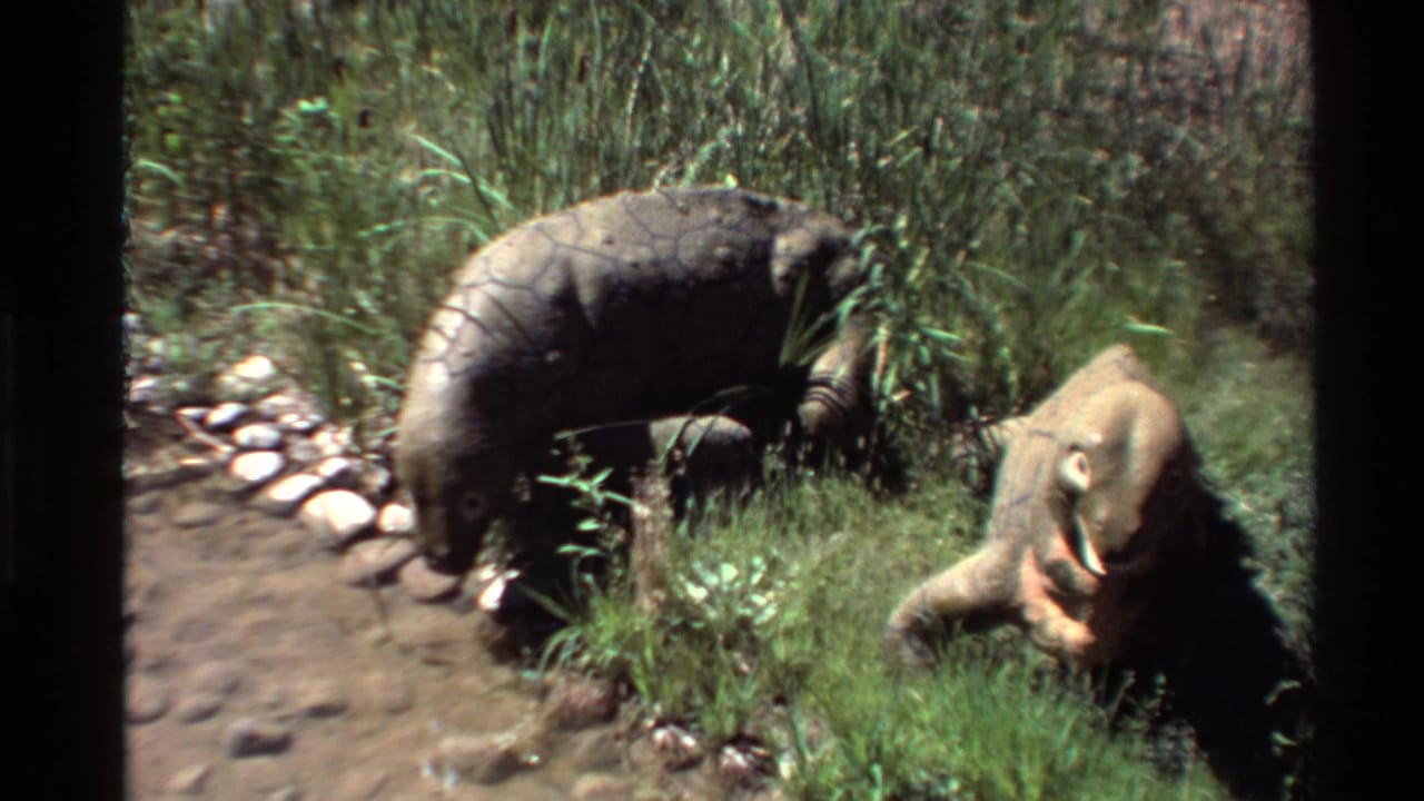 Final frame of the 1980 home movie shows the Moschops models posed among grass, rocks, and a shallow dirt area.