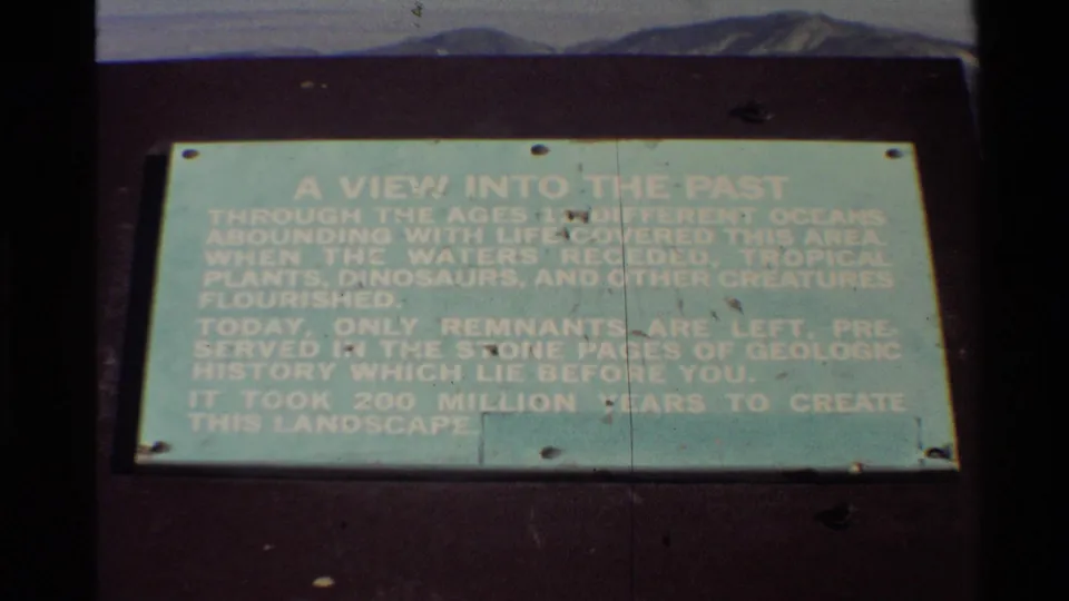 1980 Western USA home-movie frame of the same pale green interpretive sign, slightly soft with visible 8mm wear.