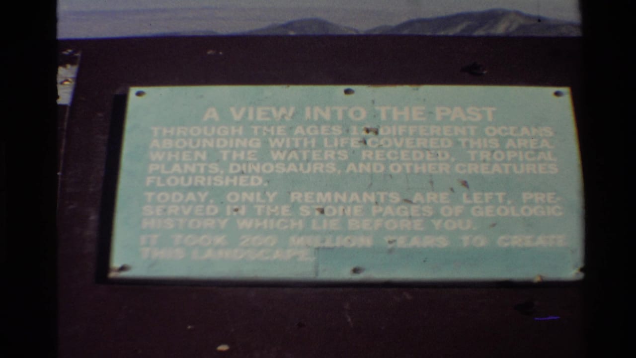 1980 Western USA frame of a pale green interpretive geology sign, partially softened by exposure and film fading.