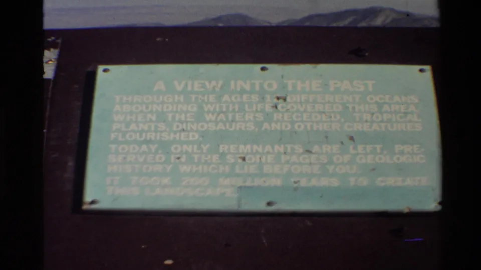 1980 Western USA frame of a pale green interpretive geology sign, partially softened by exposure and film fading.