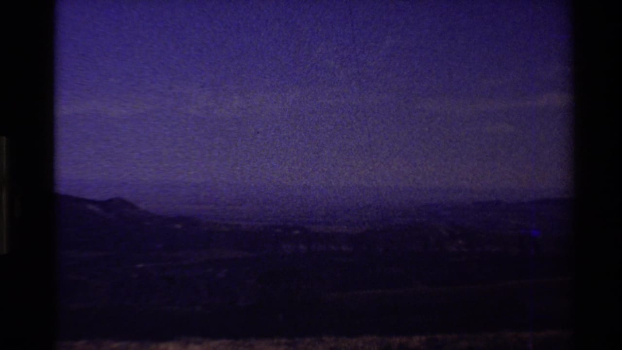 End-of-reel 8mm frame from the 1980 Western USA clip, with purple color shift over a darkened hill horizon.