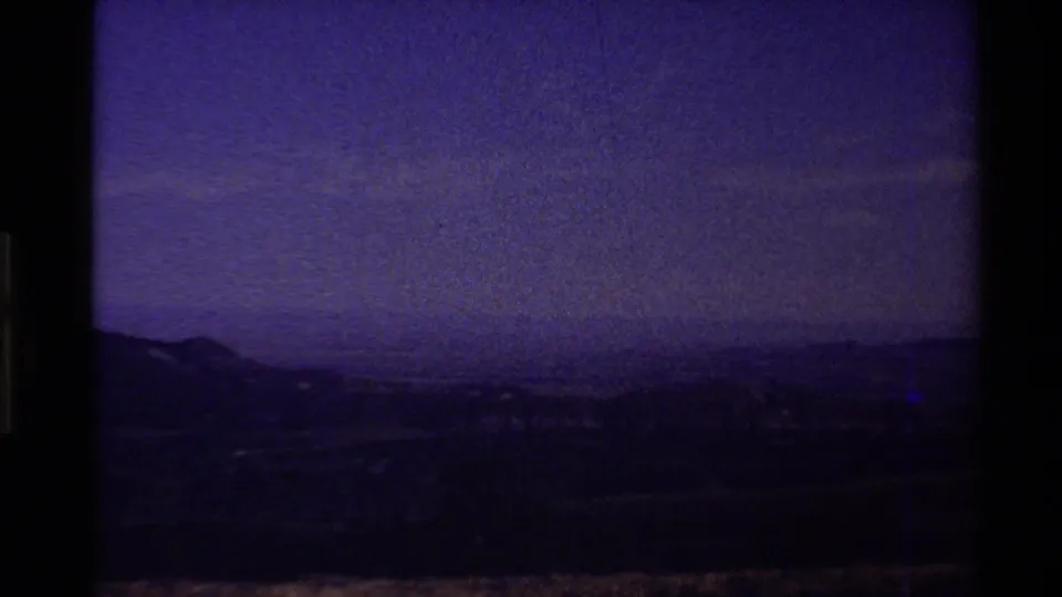 End-of-reel 8mm frame from the 1980 Western USA clip, with purple color shift over a darkened hill horizon.