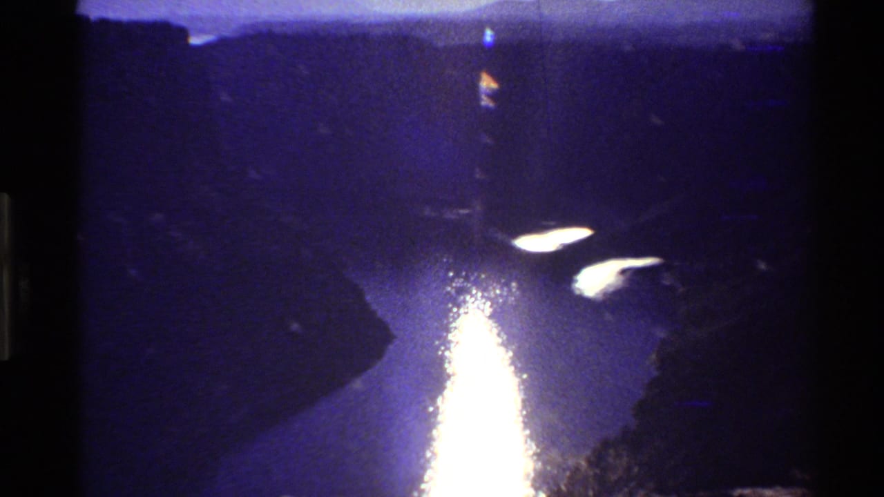 1980 8mm Western USA footage shows intense sunlight reflecting on river water between steep canyon slopes.