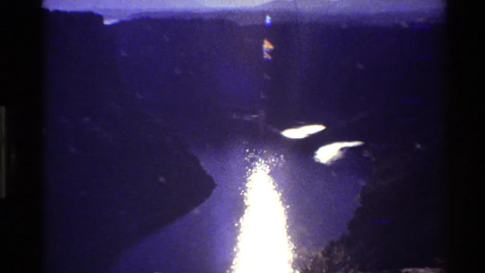 1980 8mm Western USA footage shows intense sunlight reflecting on river water between steep canyon slopes.