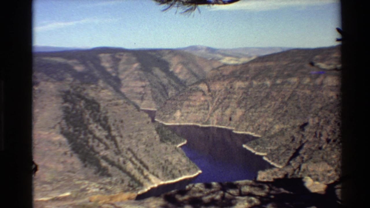 Canyon vista with winding blue water and steep layered rock walls.