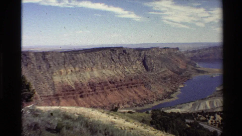 1980 Western U.S. home-movie view of layered canyon cliffs and a winding reservoir from an elevated overlook.