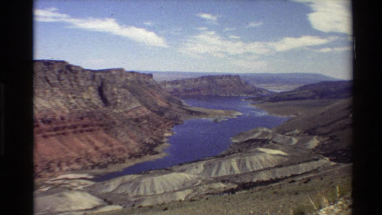 Reservoir and rugged canyon hills seen from a high wide viewpoint.