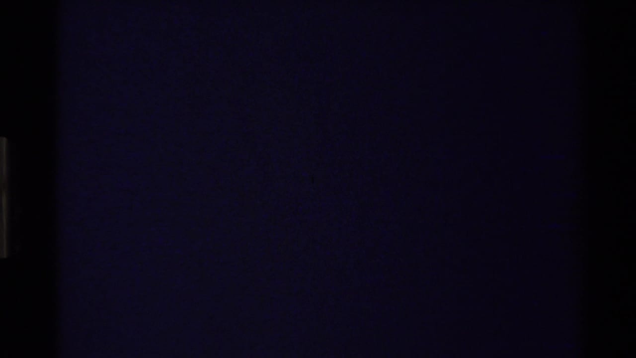 Dark end frame from the 8mm scan, suggesting the shot or reel has run out after the canyon river view.