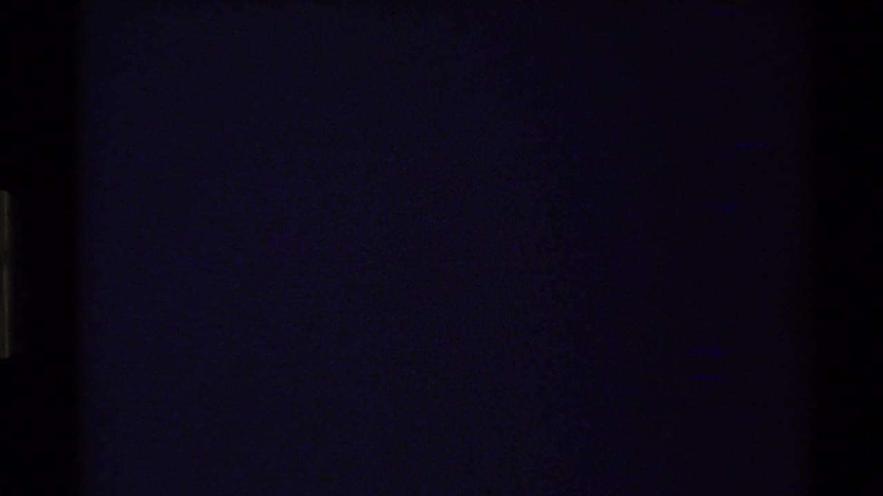 Mostly dark transitional frame with faint film edge detail.