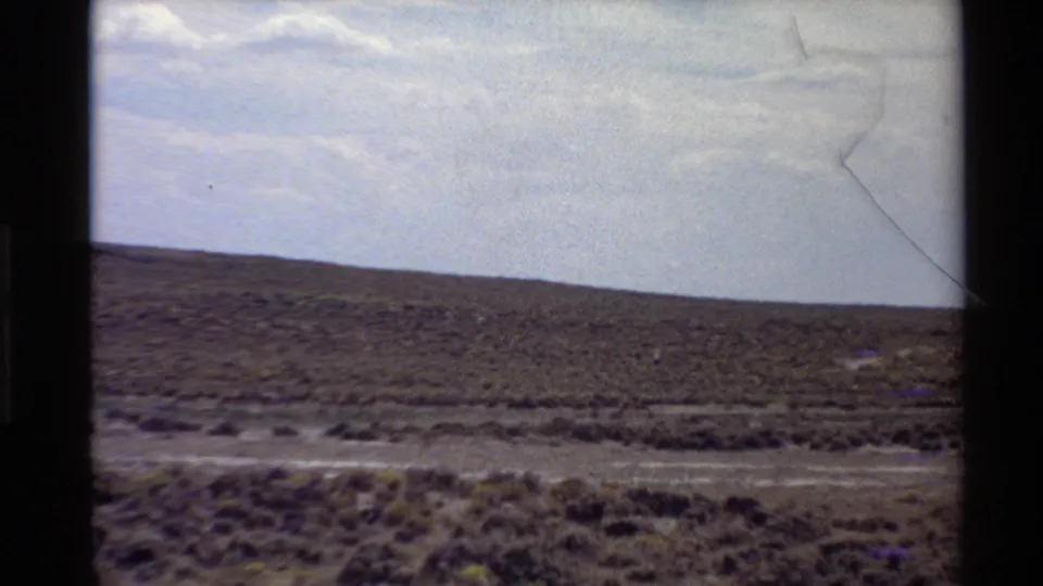 Distant antelope moves through Western U.S. scrub grassland in a soft, grainy 8mm travel frame from 1980.