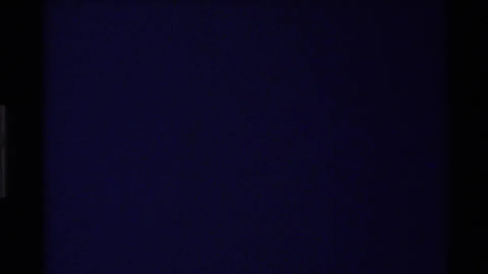 Transitional 8mm frame dominated by dark blue exposure, with minimal visible scene detail.
