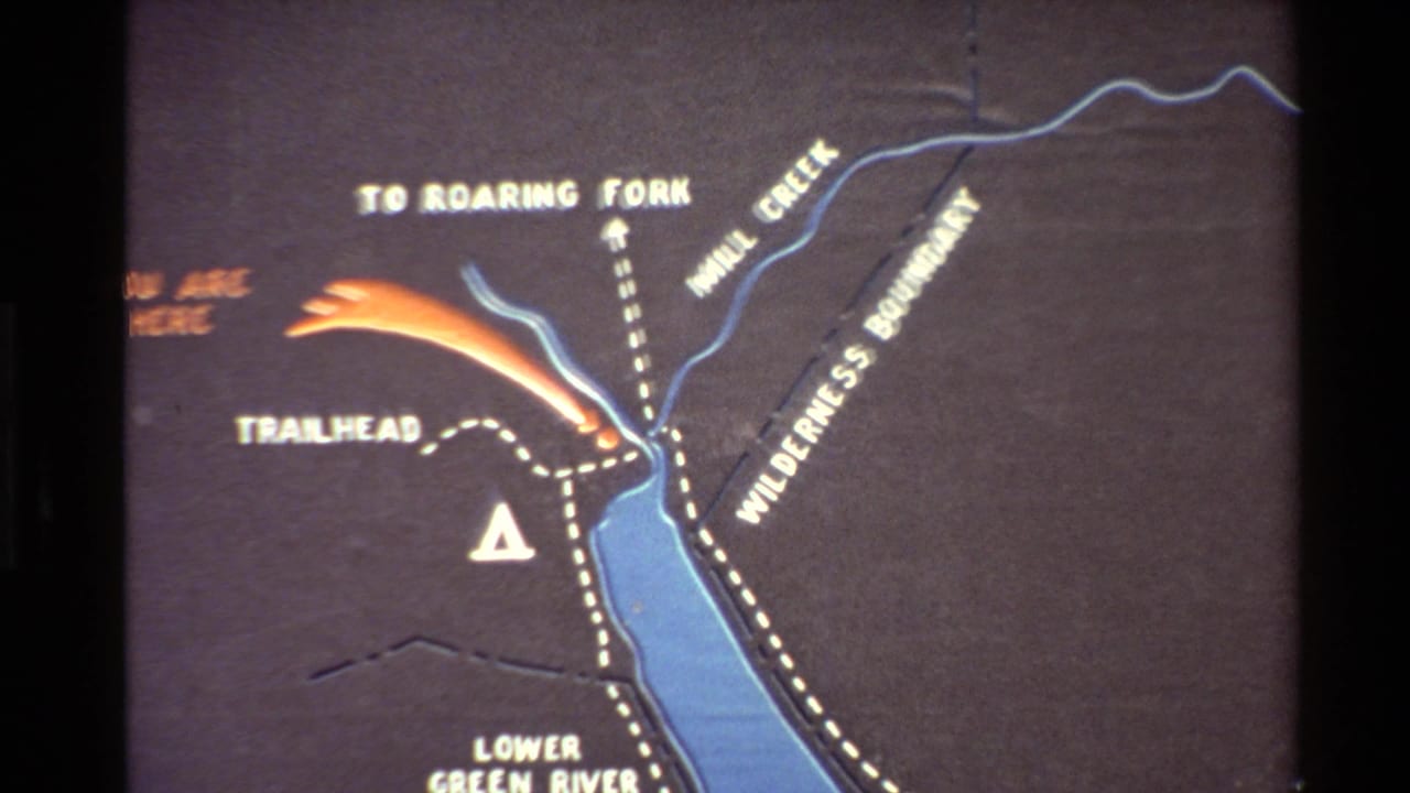 1980 home-movie frame showing a Bridger National Forest area map with Lower Green River Lake, Mill Creek, trailhead text, and wilderness boundary markings.