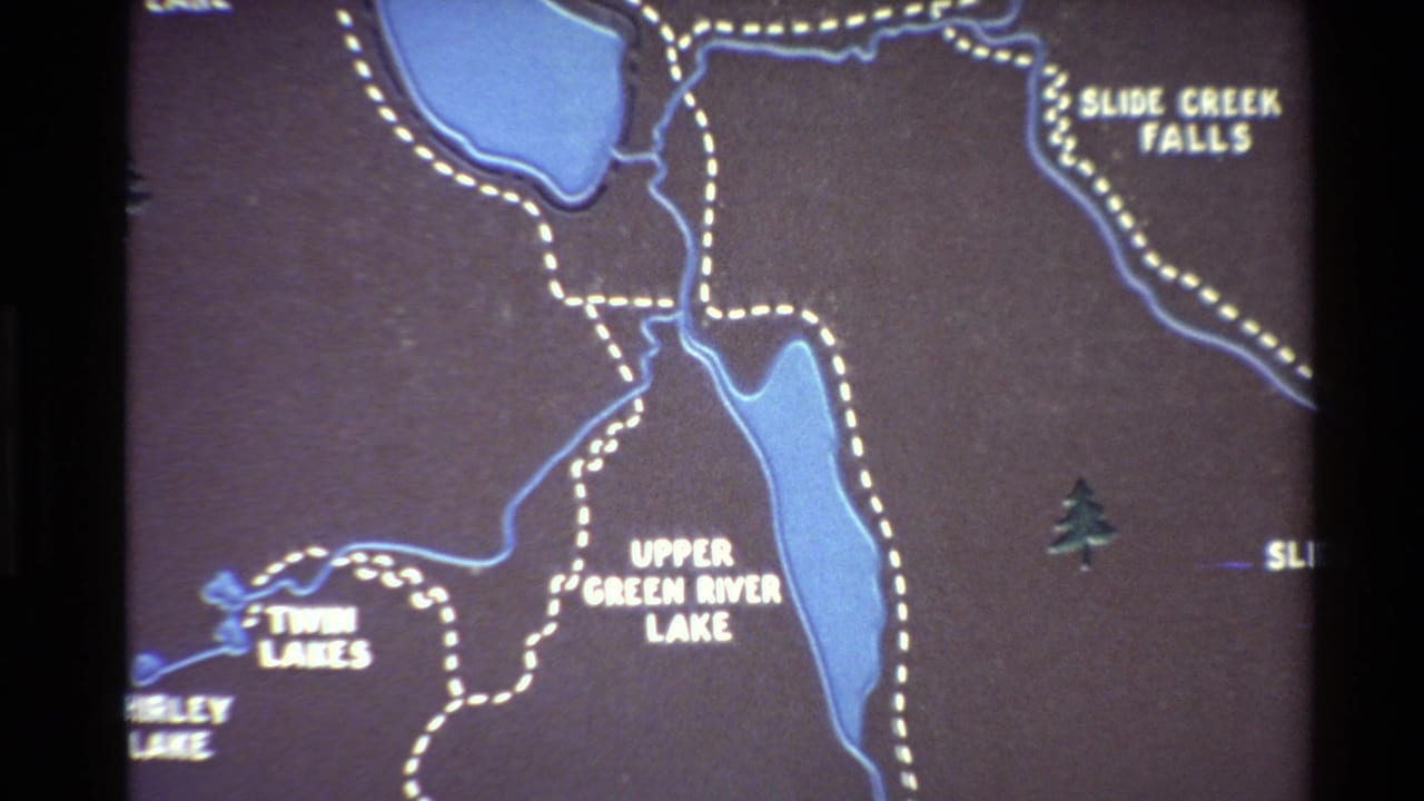 1980s 8mm frame showing a close view of a Western USA park map with blue lakes, dotted trails, and white labels.