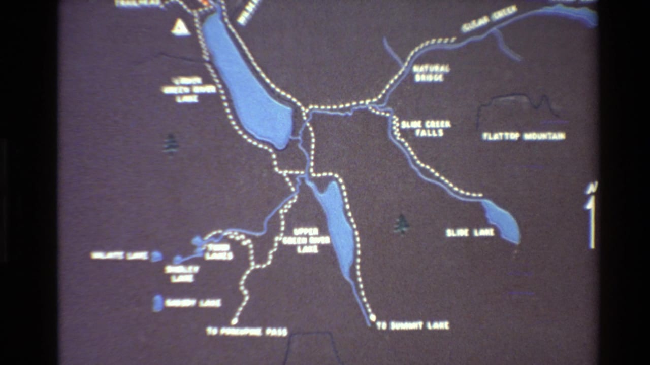 Wider map view with blue lakes, dotted routes, white labels, and a compass arrow at the right edge.