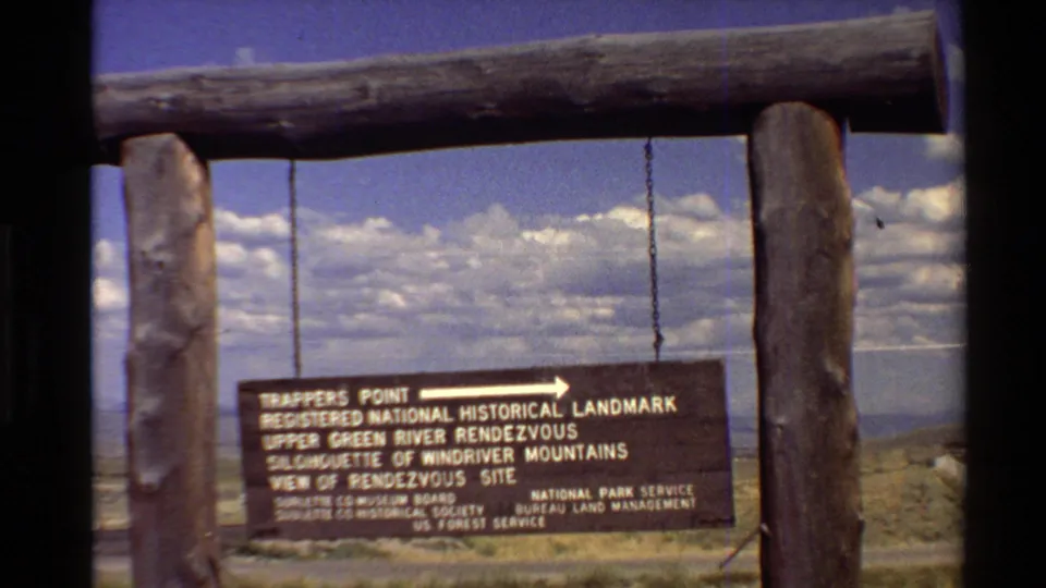 Visitor-shot 1980 frame showing the Trappers Point sign, agency text, and mountain-facing arrow in a Western U.S. setting.