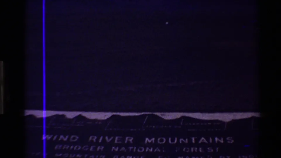 Dark 8mm title-card frame with handwritten-style text identifying Wind River Mountains and Bridger National Forest.