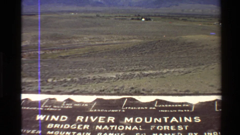 Final 8mm frame of the Western U.S. landscape, with distant mountains and Wind River Mountains Bridger National Forest text partly visible below.