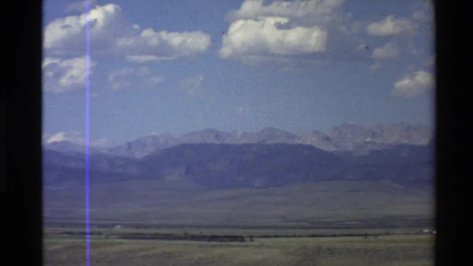 Western U.S. 8mm home-movie frame from 1980 showing an open valley, distant ridges, and partly cloudy sky.