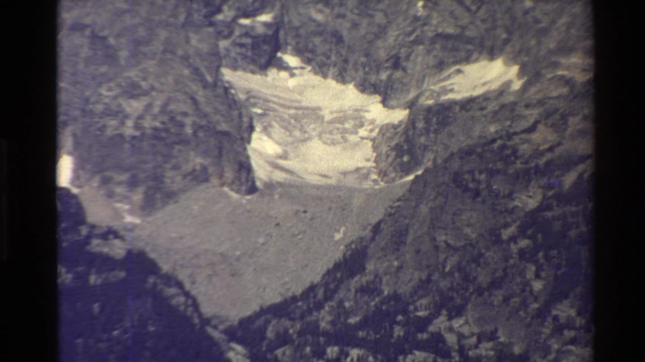 Distant glacier or snowfield framed by dark rocky mountain slopes.