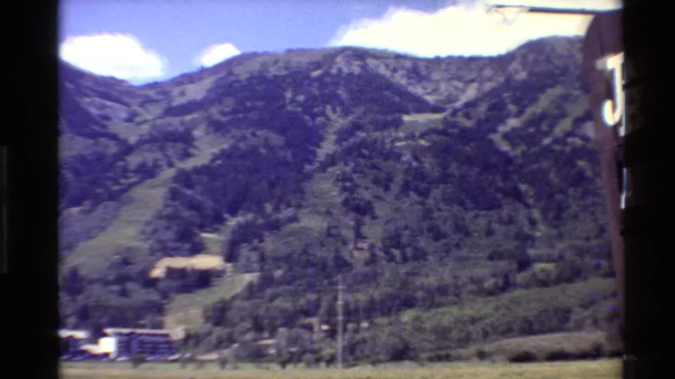 Summer view of a forested mountain slope near the Jackson Hole resort area, with buildings visible at the lower edge.