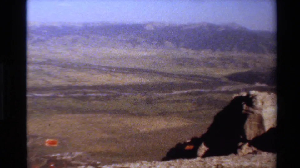 Western USA 8mm frame where the camera has panned across the valley, leaving rocks at the edge of the composition.