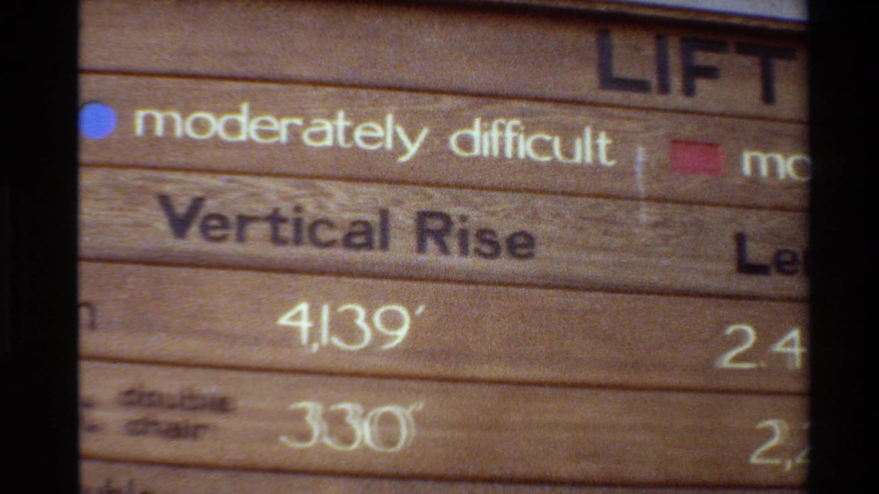 1980 Western USA 8mm close-up of a wooden ski lift sign with a moderately difficult marker, vertical rise text, and partial length column.