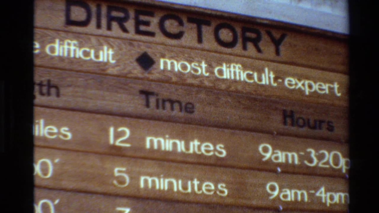 Wooden trail directory board listing hiking difficulty, time, and hours.